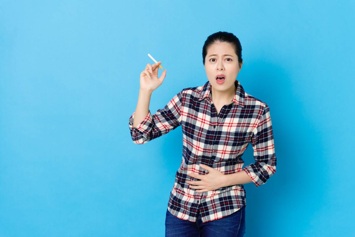 Woman smoking and increasing her breast cancer risk